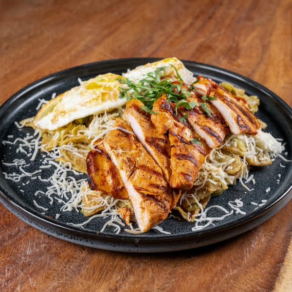 Sonora Mexican Kitchen's grilled chicken with green chilaquiles, fried egg, and shredded cheese.